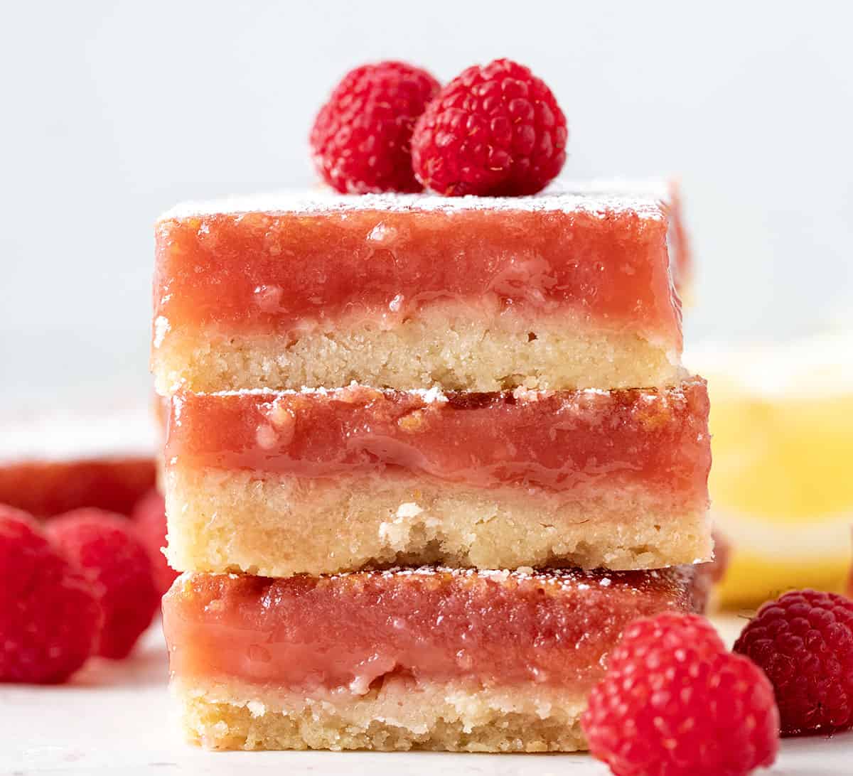 Stack of Raspberry Lemon Bars on a white table looking straight on.