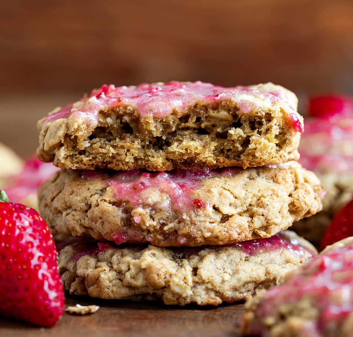 Stack of Strawberry Iced Oatmeal Cookies with the top cookie halved showing the inside texture.