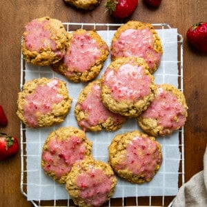 Strawberry Iced Oatmeal Cookies on a rack on a wooden table from overhead.
