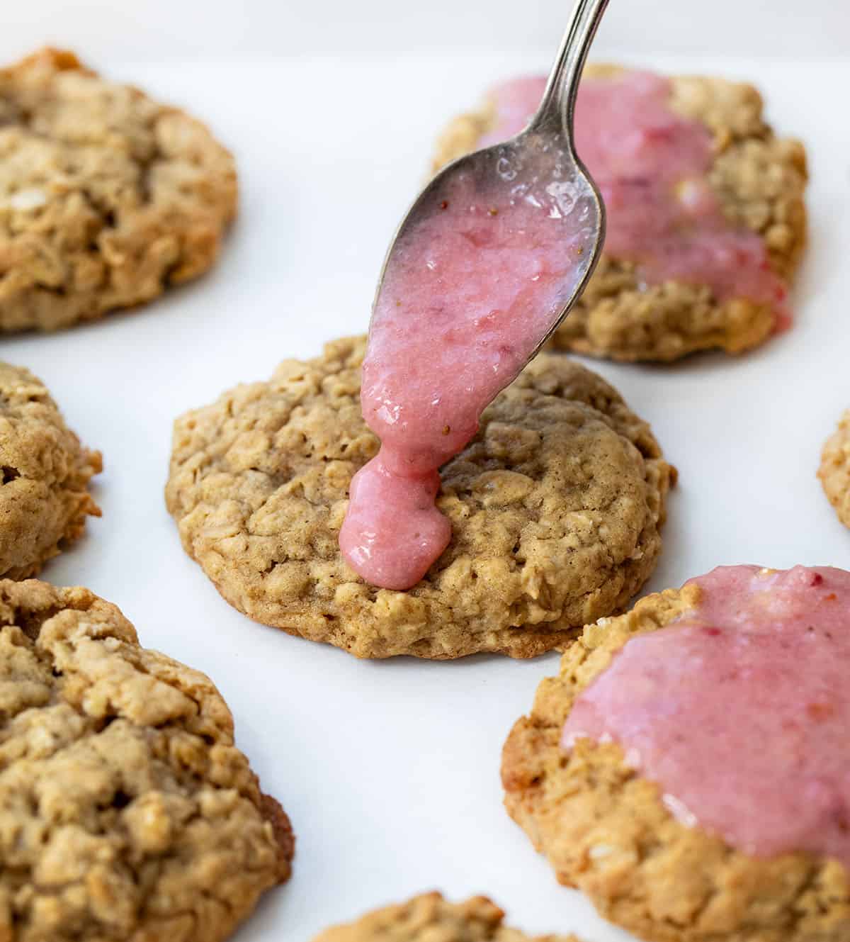 Adding strawberry sauce to oatmeal cookies.