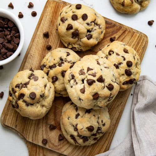 Chocolate Chip Cookies on a cutting board on a white table from overhead.