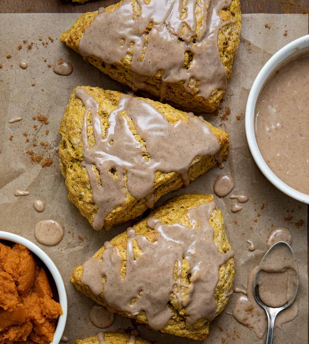 Pumpkin Scones on a wooden table on parchment paper from overhead.