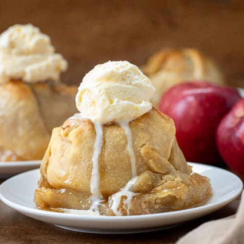 Apple Dumpling on a white plate topped with vanilla ice cream.