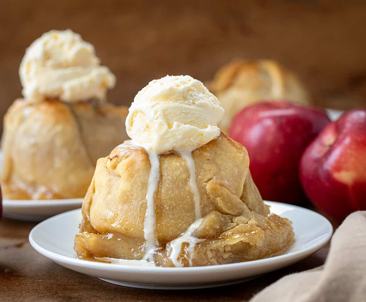 Apple Dumpling on a white plate topped with vanilla ice cream.