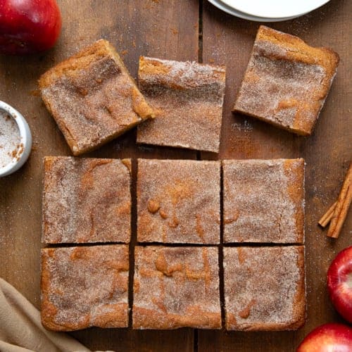 Apple Cider Blondies on a wooden table that are cut into squares with a few separated shot from overhead.