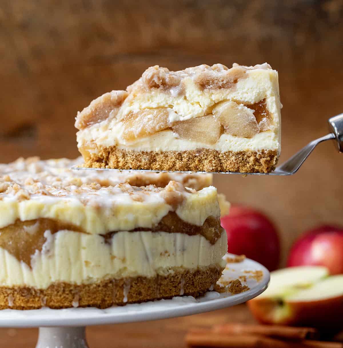 Server picking up a piece of Apple Crumble Cheesecake from the cake plate.