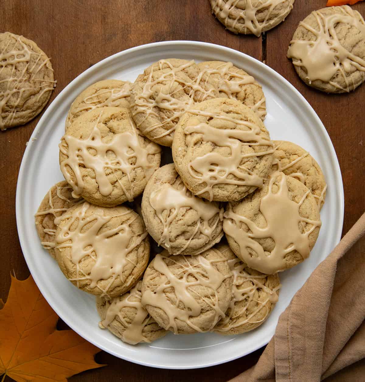 Plate of Maple Brown Sugar Cookies on a wooden table with cookies and leaves around from overhead.