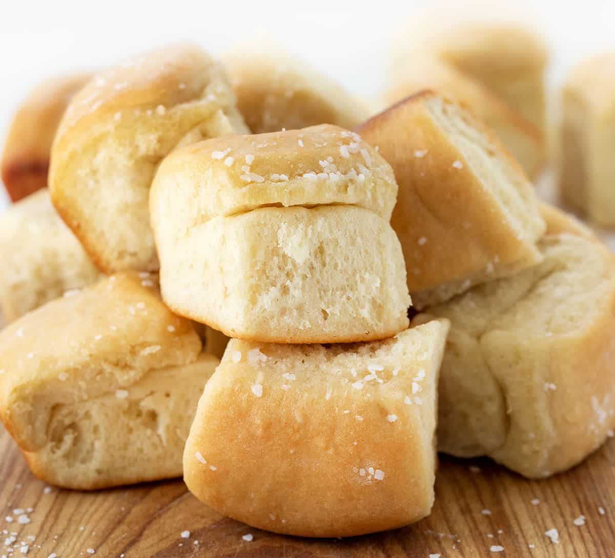 Parker House Rolls on a cutting board close up showing tender bread and salt.