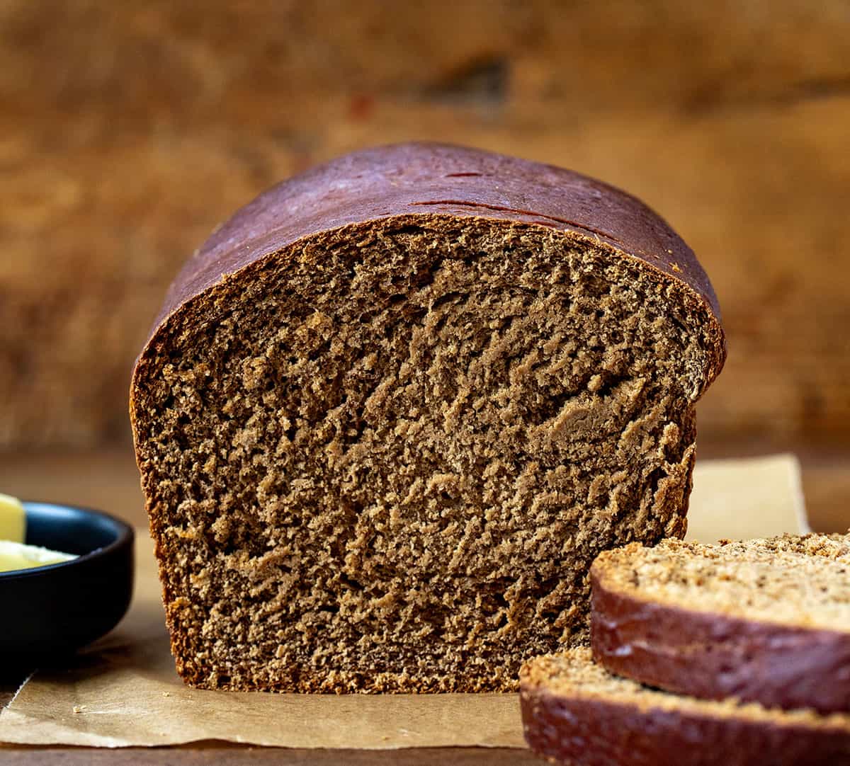 This homemade Pumpernickel Bread is a rye bread that has a rich, slightly sweet flavor with a dense, hearty texture. It's also perfect for sandwiches or a bowl of soup or stew. Cut into loaf of Pumpernickel Bread showing texture inside.