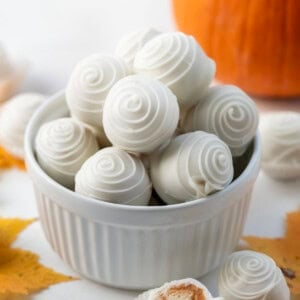 Bowl of Pumpkin Truffles on a table with autumn leaves.