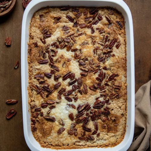 Pan of Sweet Potato Dump Cake on a wooden table with napkin from overhead.