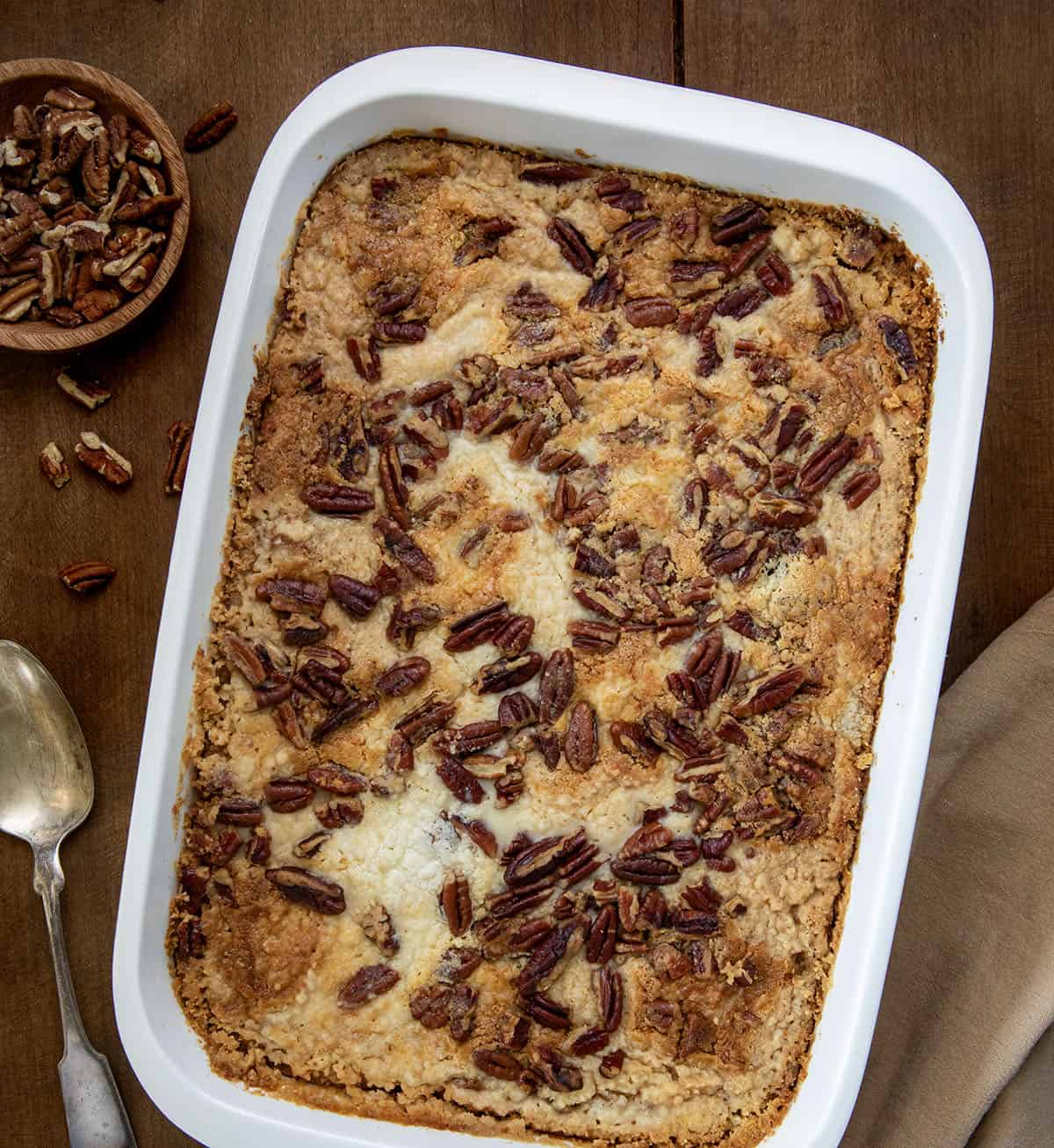 Pan of Sweet Potato Dump Cake on a wooden table with napkin from overhead.