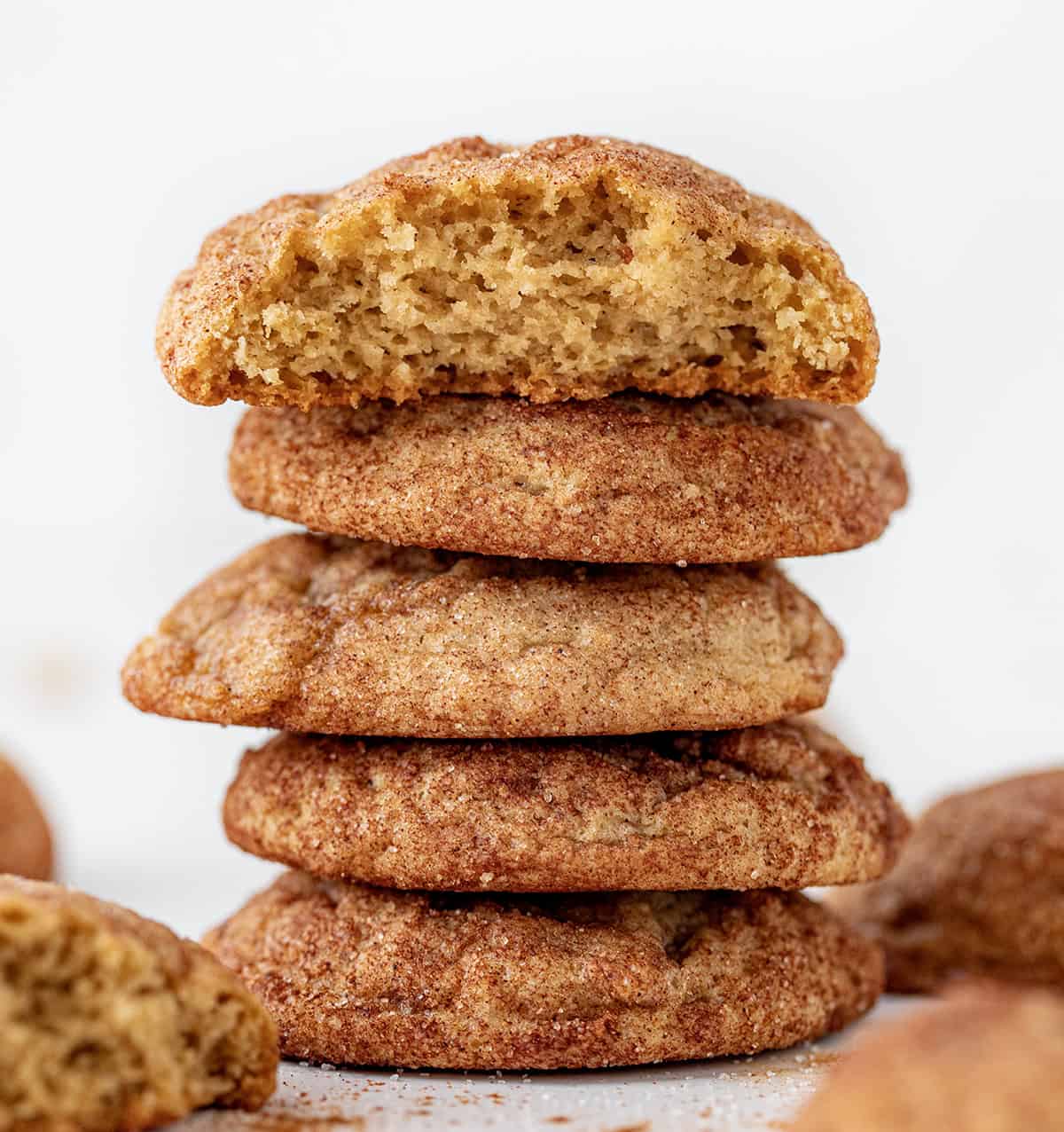 Stack of Apple Butter Snickerdoodles with top cookie broken in half showing inside texture.