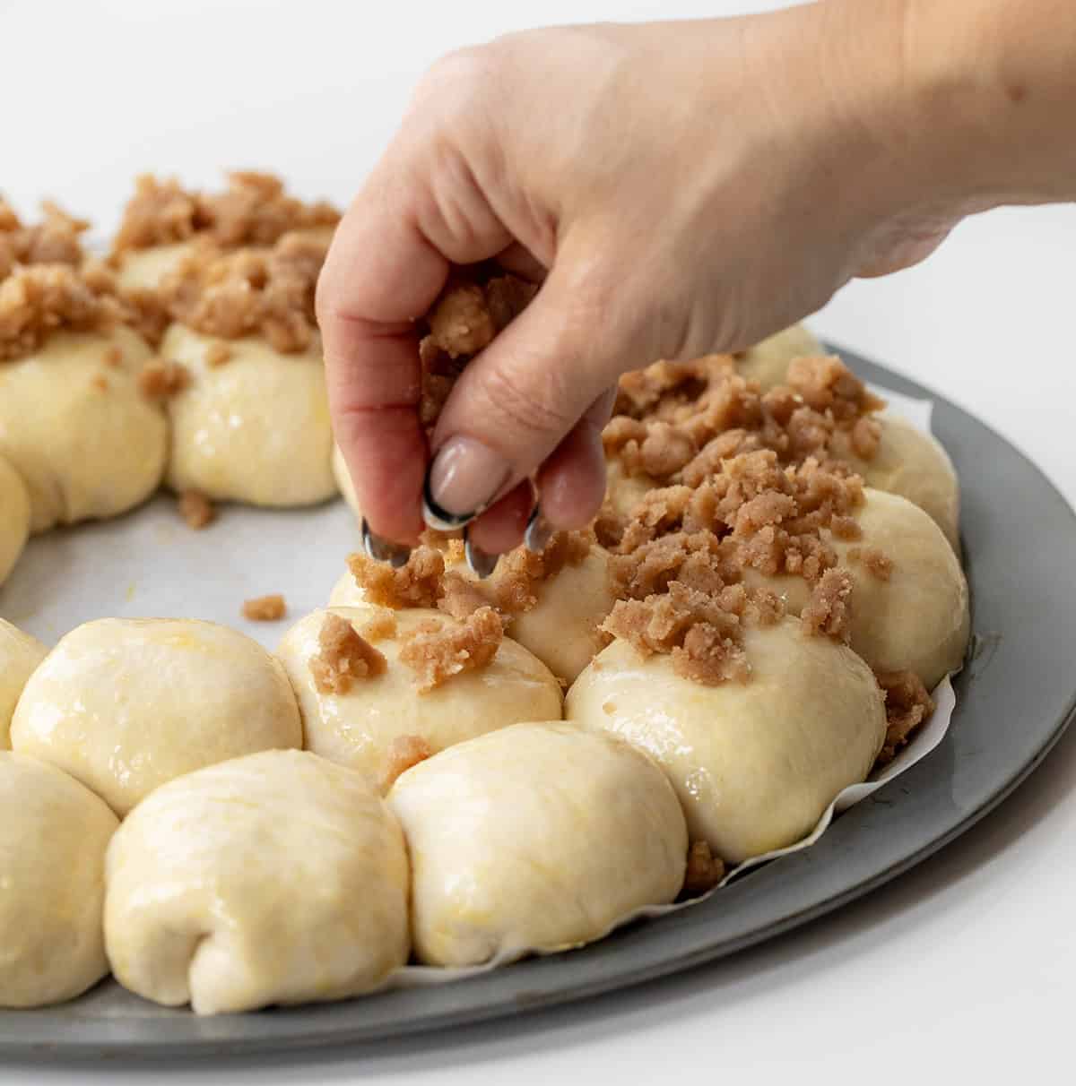 Sprinkling crumble over Apple Pie Bombs and formed into a wreath shape.