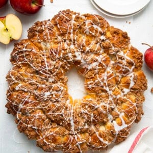 Apple Pie Bomb Wreath on a white table with apples and plates from overhead.