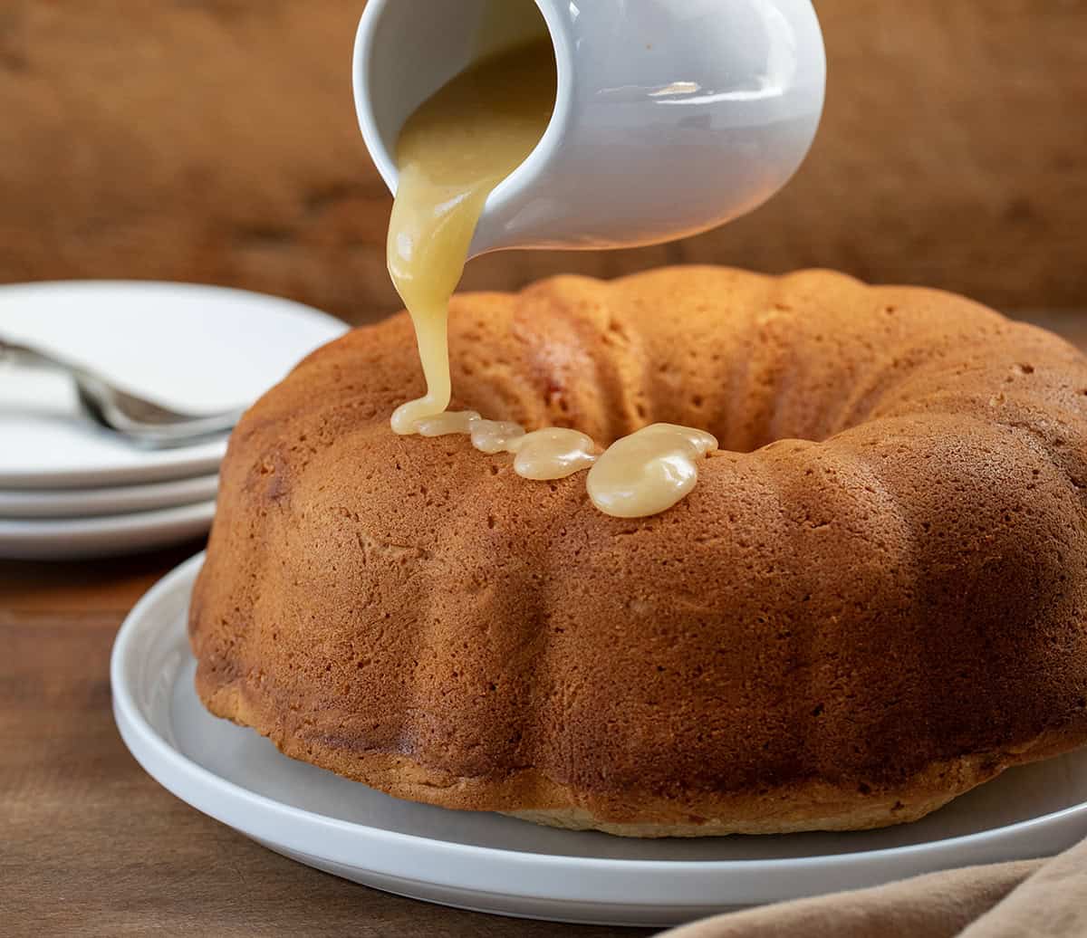 Drizzling glaze over naked Brown Sugar Maple Pound Cake.