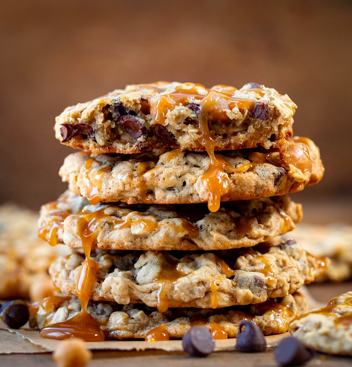 Stack of Carmelita Cookies with caramel dripping off and top cookie broken in half showing inside texture.