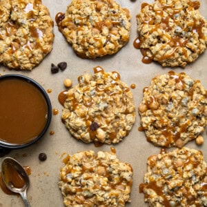 Carmelita Cookies laid out next to caramel and a spoon on parchment paper.