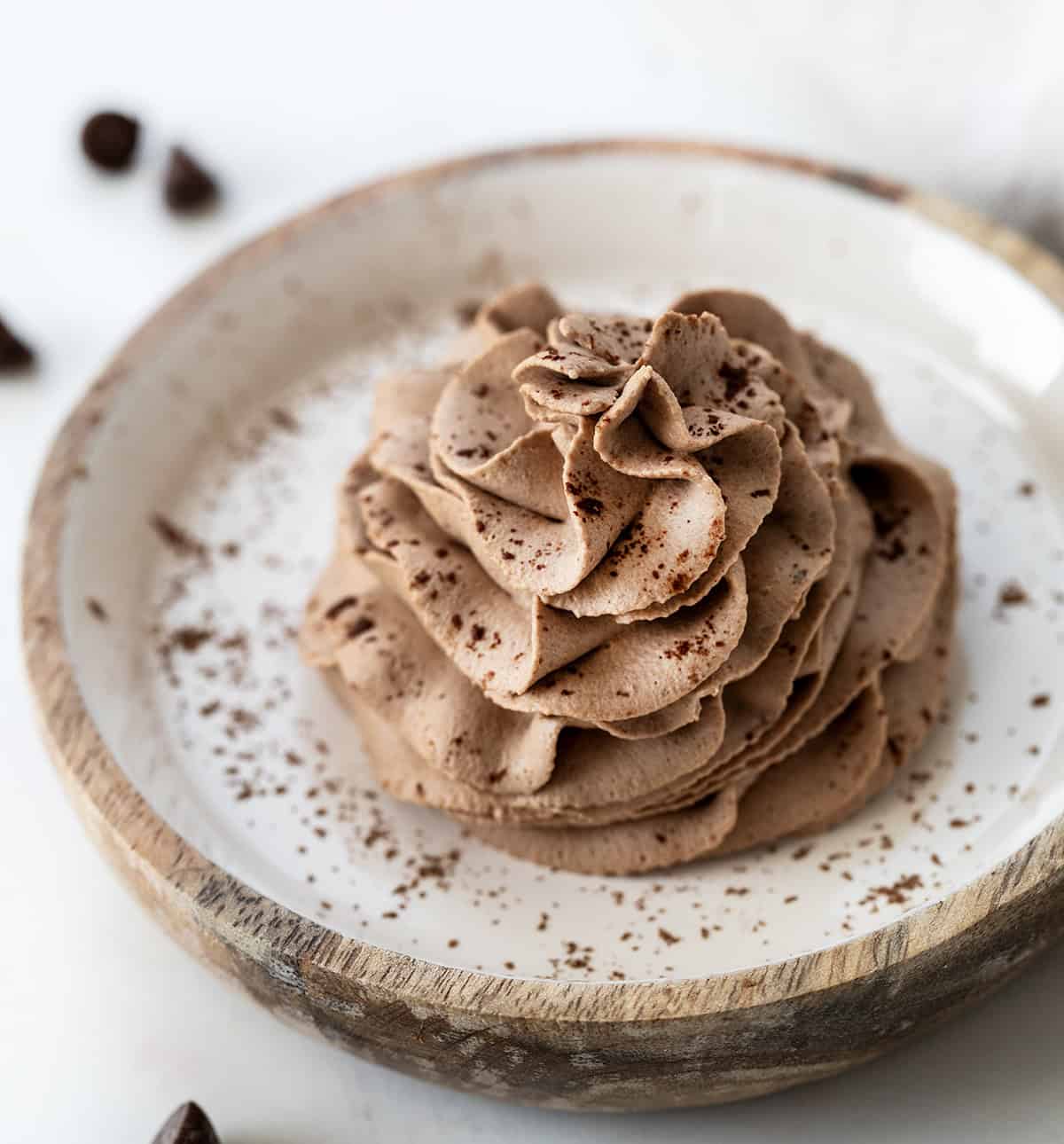 Chocolate Stabilized Whipped Cream piped onto a plate dusted with cocoa powder.