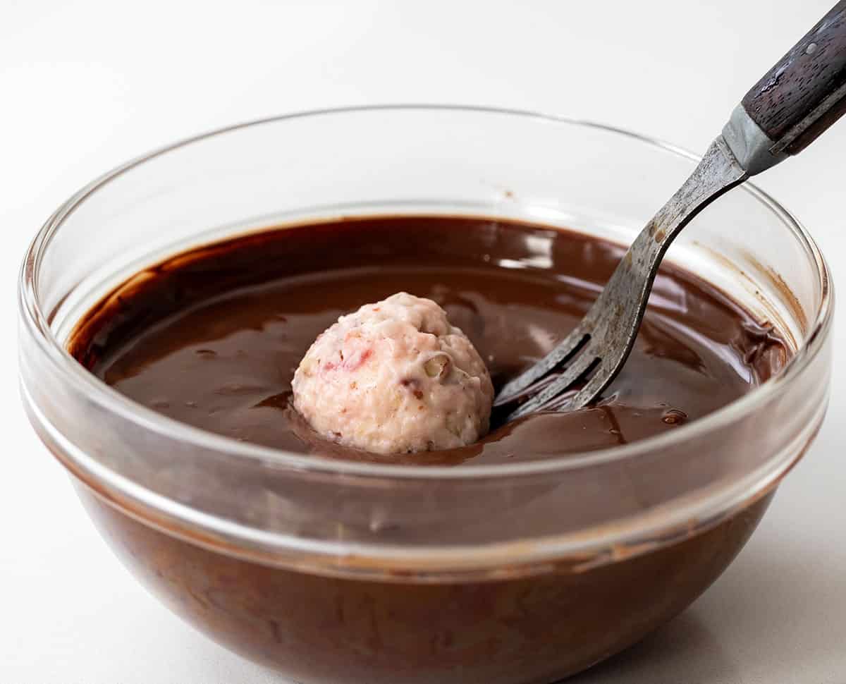 Dipping candy into melted chocolate.