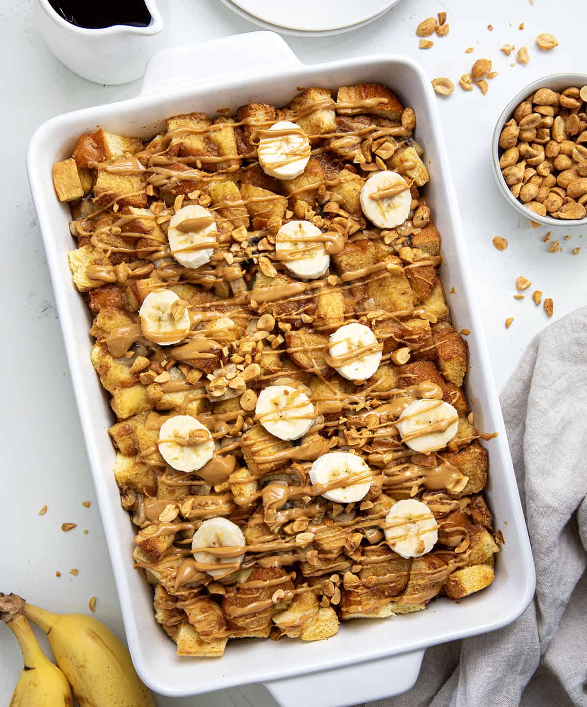 Casserole dish of Peanut Butter Banana Overnight French Toast on a white table from overhead.