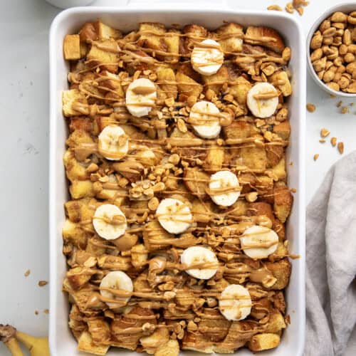 Casserole dish of Peanut Butter Banana Overnight French Toast on a white table from overhead.