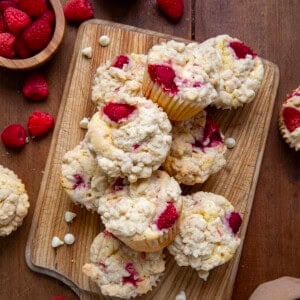 Raspberry White Chocolate Chip Muffins on a wooden cutting board from overhead.