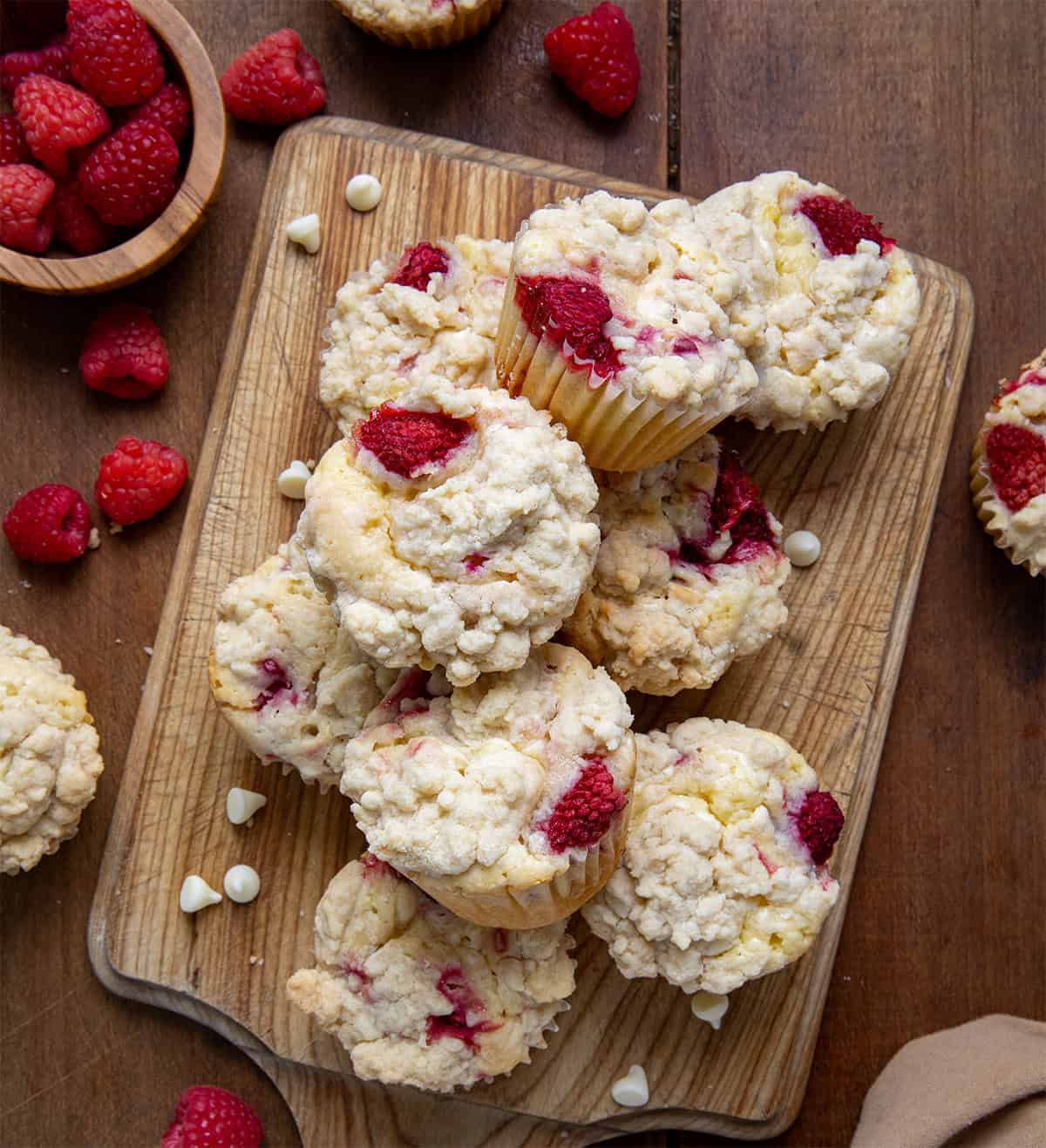 Raspberry White Chocolate Chip Muffins on a wooden cutting board from overhead. 