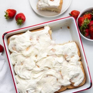 Pan of Strawberries and Cream Sweet Rolls with one missing and on a plate from overhead.