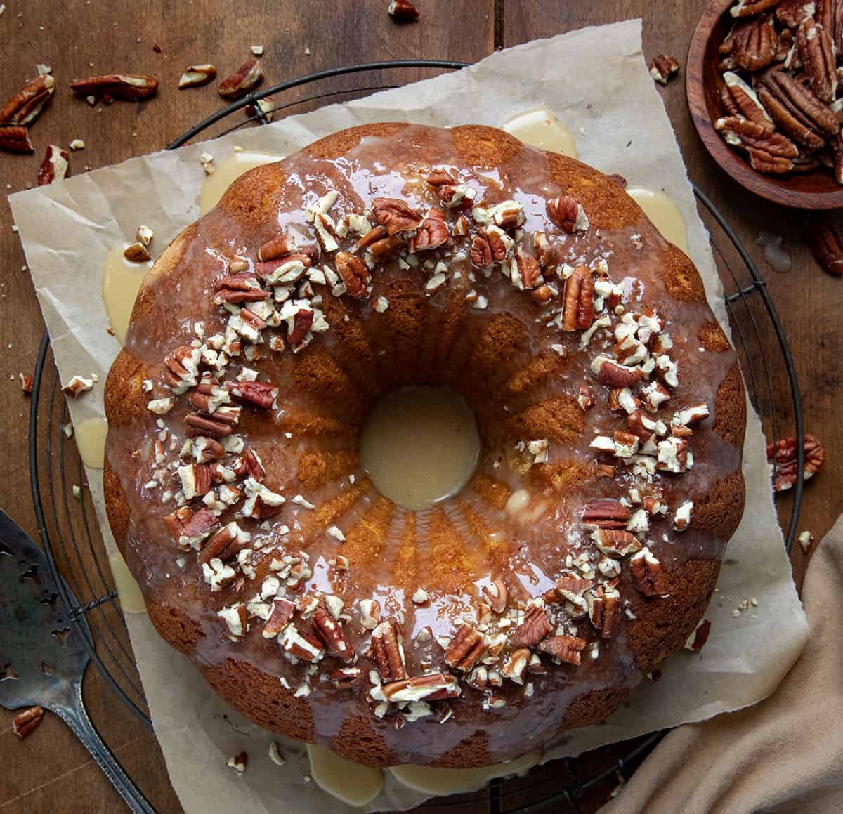 Whole Sweet Potato Pound Cake on a cooling rack with parchment paper on a wooden table from overhead.