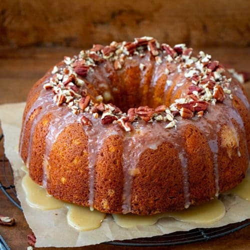 Sweet Potato Pound Cake on a piece of parchment paper on a cooling rack on a wooden table.