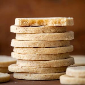 Stack of Brown Butter Cut-Out Sugar Cookies with top cookie halved showing inside texture.