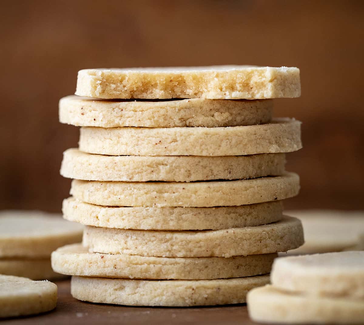 Stack of Brown Butter Cut-Out Sugar Cookies with top cookie halved showing inside texture.