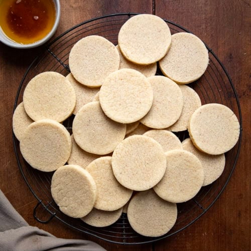 Brown Butter Cut-Out Sugar Cookies on a cooling rack on a wooden table from overhead.