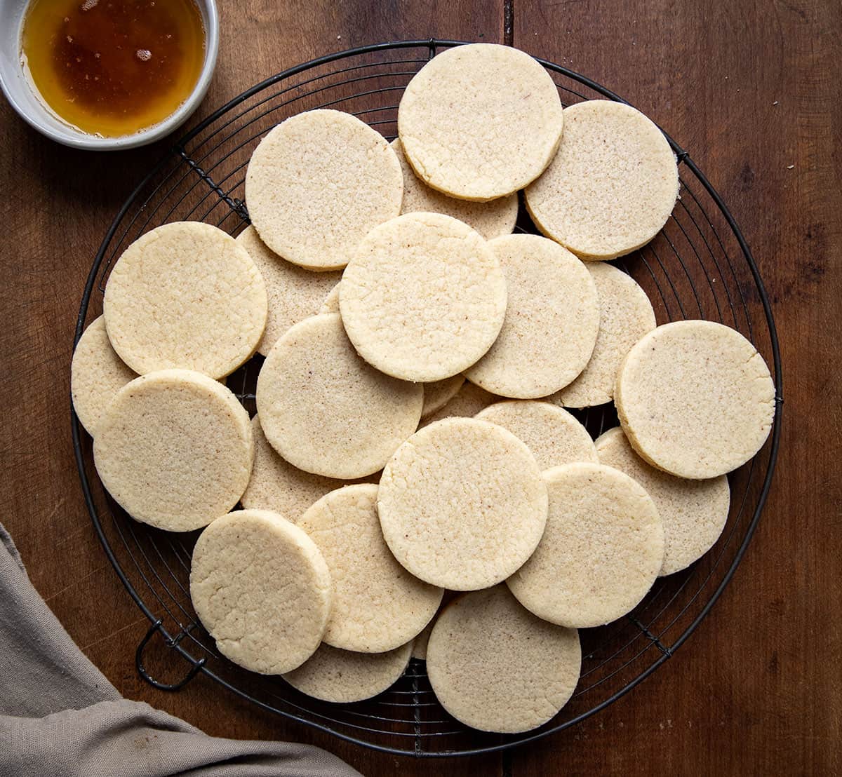 Brown Butter Cut-Out Sugar Cookies on a cooling rack on a wooden table from overhead.