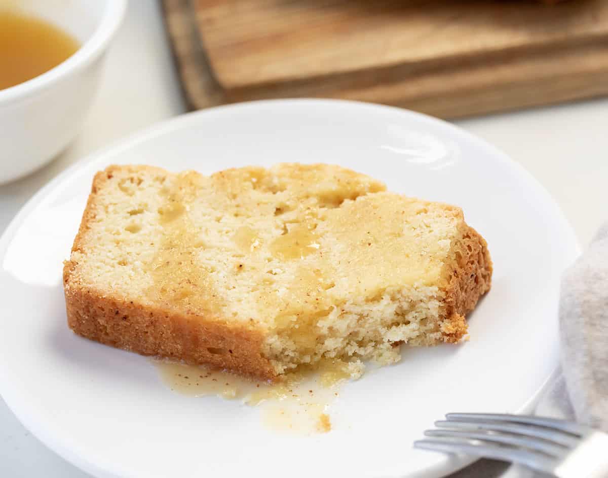 Piece of Brown Butter Pound Cake on a white plate with a bite removed.