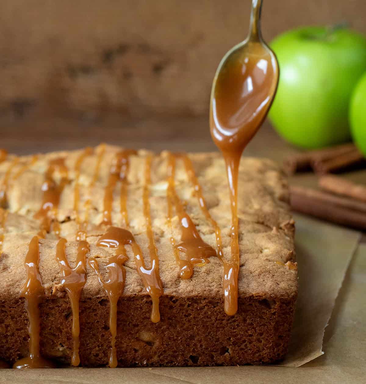 Drizzling caramel over Apple Snack Cake with a spoon.