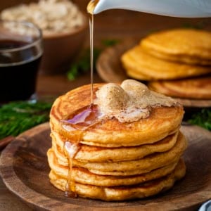 Pouring syrup over a stack of Gingerbread Pancakes.