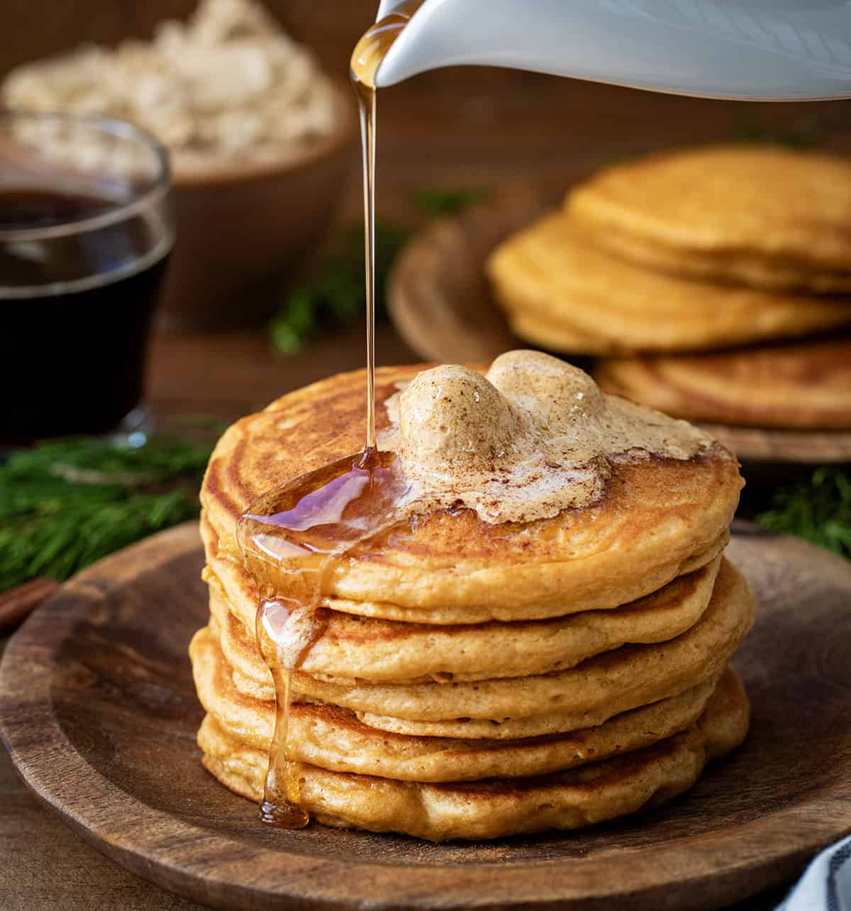 Pouring syrup over a stack of Gingerbread Pancakes.