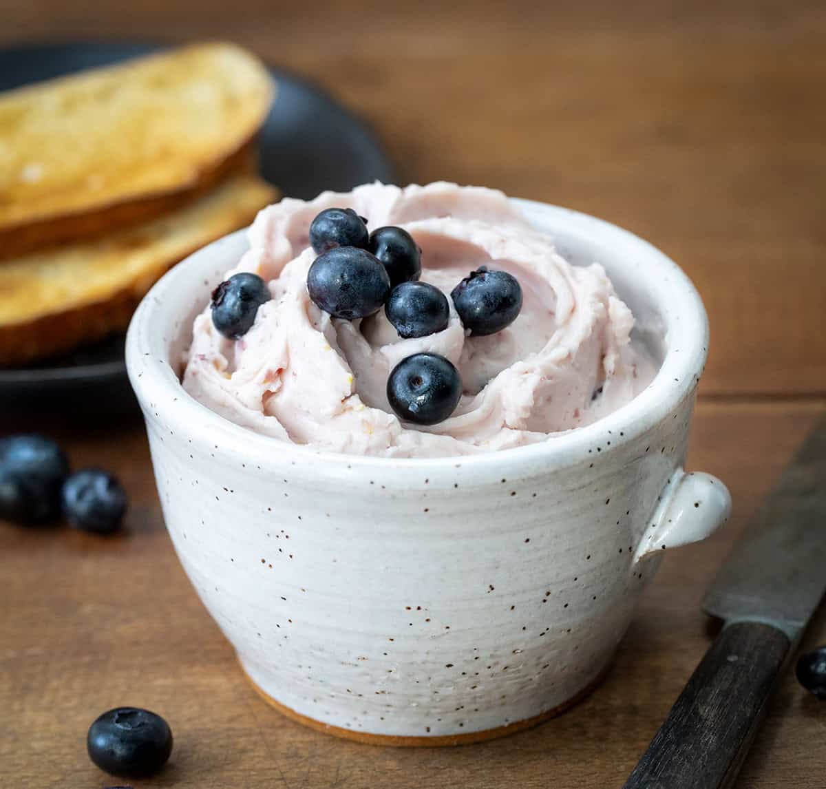 Cup of Lemon Blueberry Butter with toast in the background.