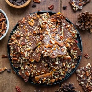 Tray of Maple Pecan Christmas Crack broken into pieces on a wooden table from overhead.