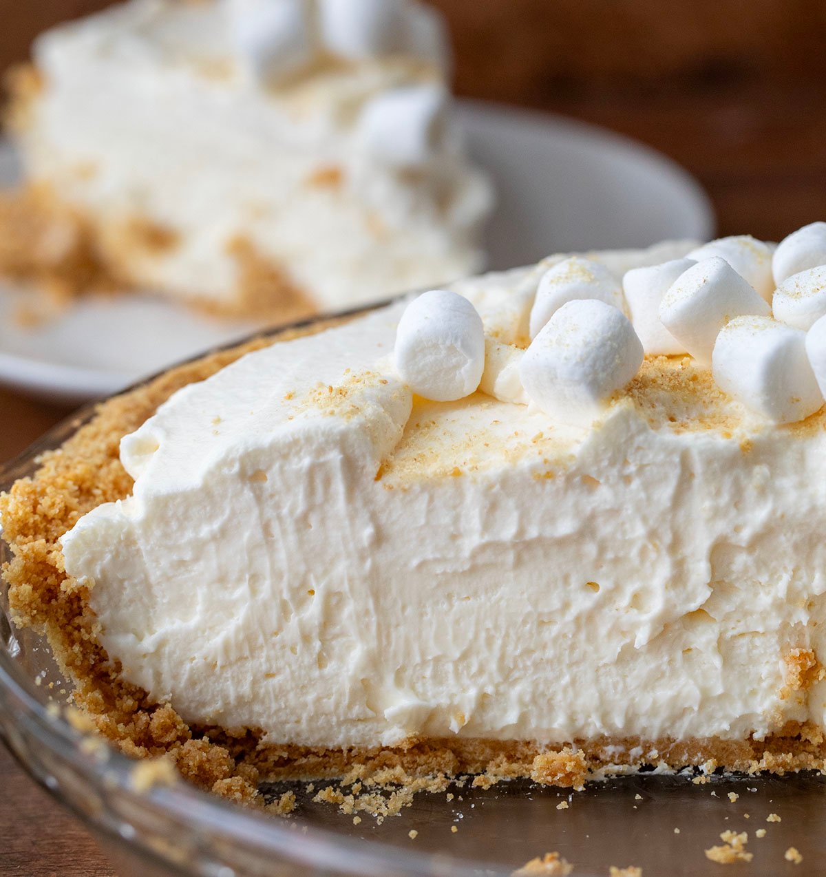 Marshmallow Cream Cheesecake in the dish with pieces removed showing the cut into cheesecake.