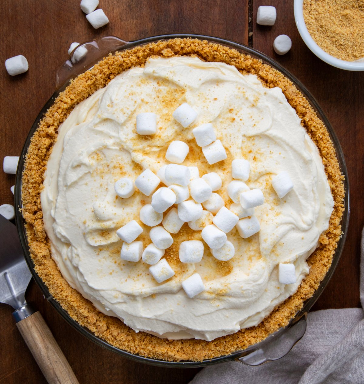 Whole Marshmallow Cream Cheesecake on a wooden table from overhead. 