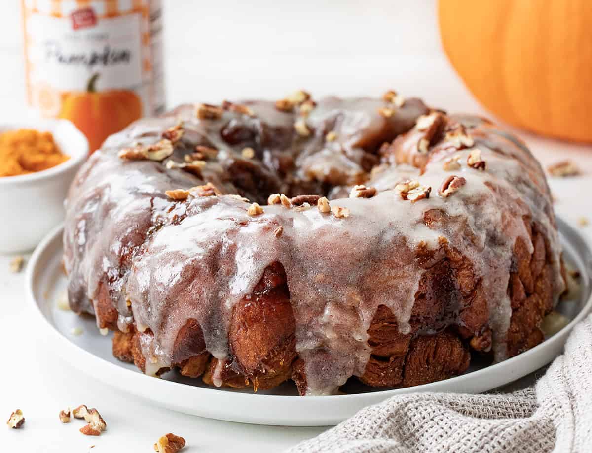 Whole Pumpkin Monkey Bread on a white platter with pumpkin puree in the background.