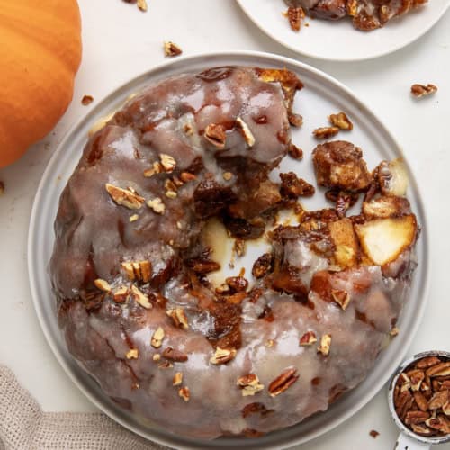 Pumpkin Monkey Bread on a white platter with some pieces removed and shot from overhead.