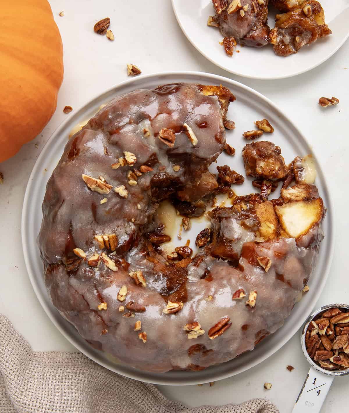 Pumpkin Monkey Bread on a white platter with some pieces removed and shot from overhead.