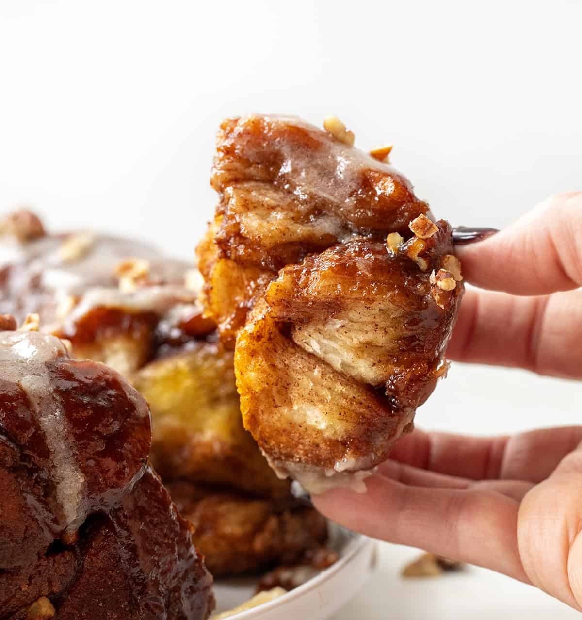 Hand holding gooey pieces of Pumpkin Monkey Bread.