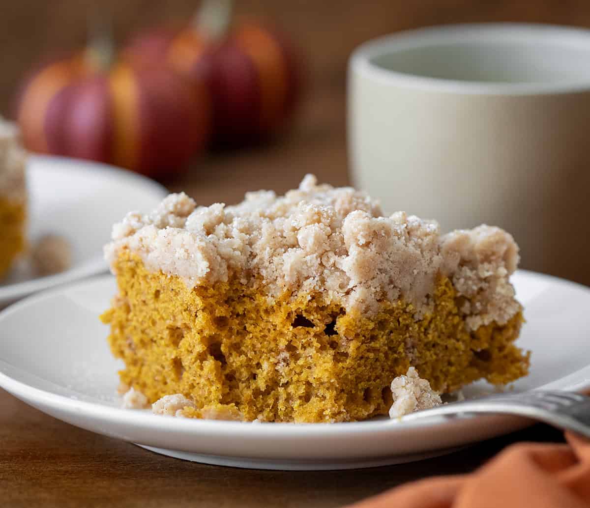 Piece of Pumpkin Spice Coffee Cake on a white plate with a bite taken out.