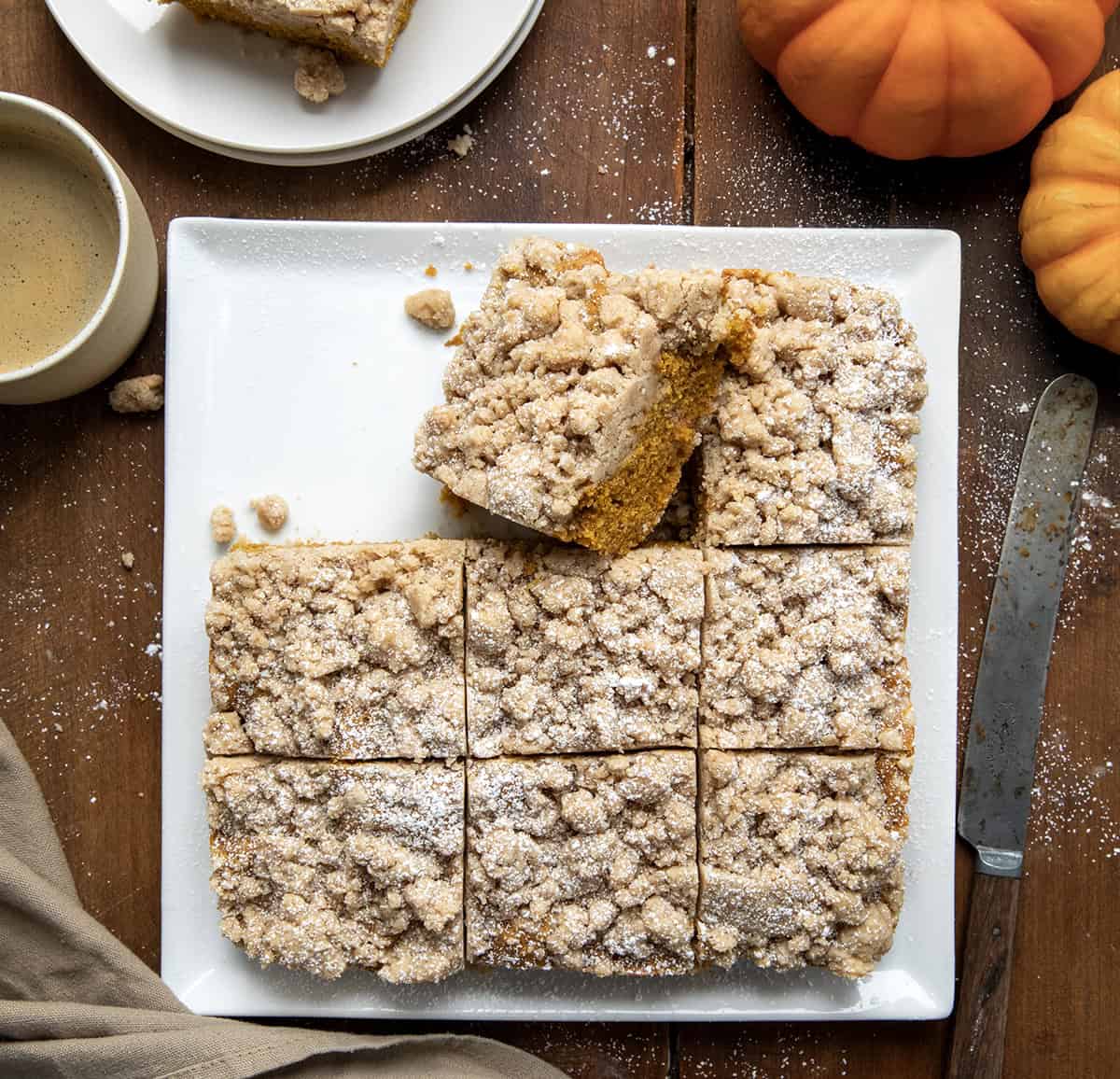 Pumpkin Spice Coffee Cake on a white platter cut into pieces with one piece on its side.