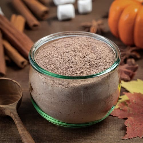 Pumpkin Spice Hot Cocoa Mix in a jar on a wooden table.
